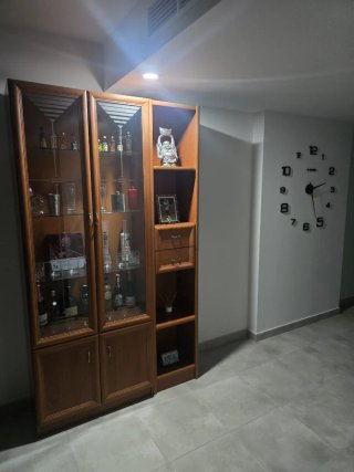 Sofá sheslong gris, sillón y vitrina de madera