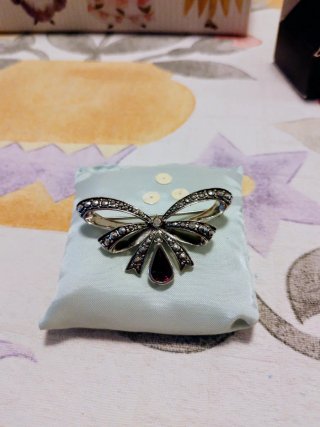 Broche vintage lazo con piedra roja.