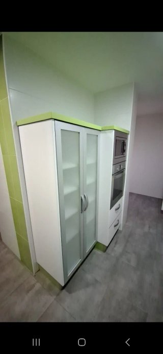 Cocina con muebles y encimera de cocina verde pie