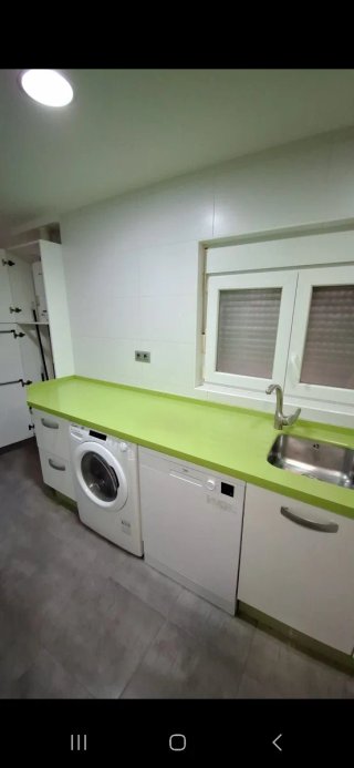 Cocina con muebles y encimera de cocina verde pie