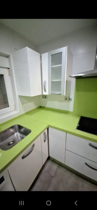 Cocina con muebles y encimera de cocina verde pie