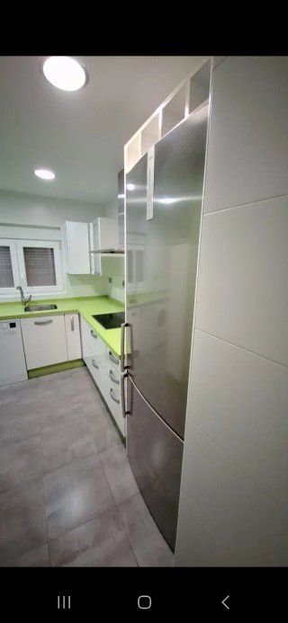 Cocina con muebles y encimera de cocina verde pie