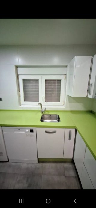 Cocina con muebles y encimera de cocina verde pie