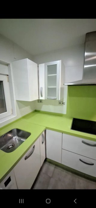 Cocina con muebles y encimera de cocina verde pie