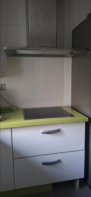 Cocina con muebles y encimera de cocina verde pie