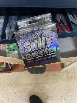 Caja de pesca con accesorios y plomas para caña
