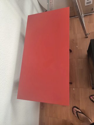 Mesa roja con pie de máquina de coser