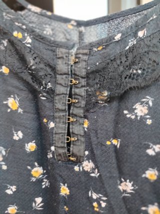 Top negro con corchetes y flores