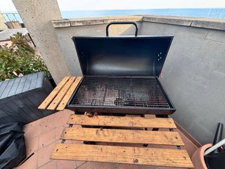 Barbacoa de carbón con mesas laterales