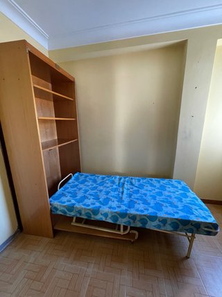 Estantería de madera con cama plegable.