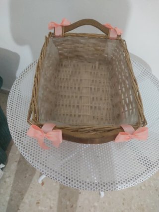 Cesta de mimbre decorada con lazos rosas
