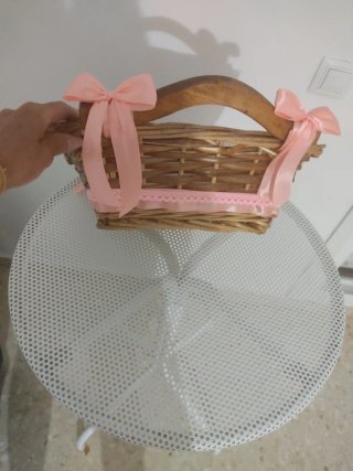 Cesta de mimbre decorada con lazos rosas