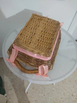 Cesta de mimbre decorada con lazos rosas