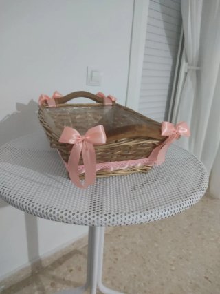 Cesta de mimbre decorada con lazos rosas