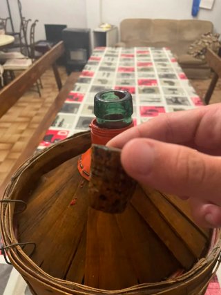 Garrafa de vidrio con cesta de madera