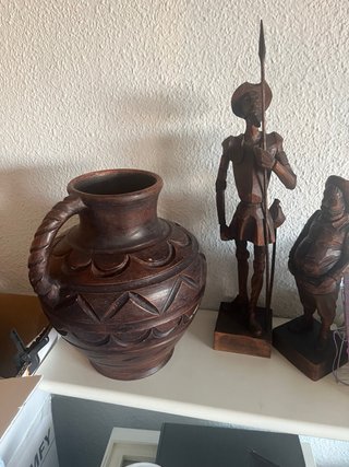 Cántaro de cerámica y figuras de madera