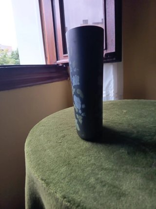 Jarrón negro con flores azul grisaceas