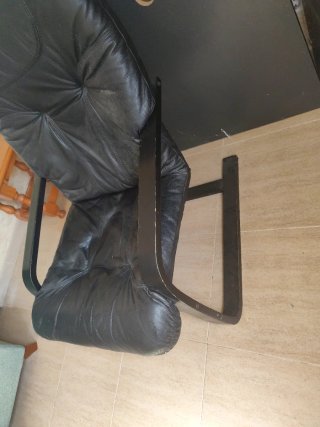 Sillón de cuero negro con patas de madera