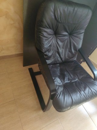 Sillón de cuero negro con patas de madera