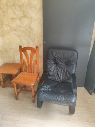 Sillón de cuero negro con patas de madera