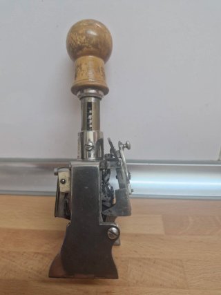 Numerador antiguo metálico con mango de madera
