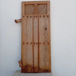 Puerta antigua madera clavos y celosía