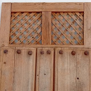 Puerta antigua madera clavos y celosía