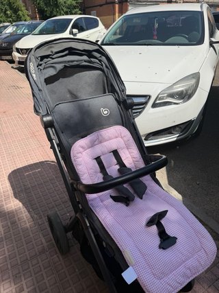 Carro de bebé gris con funda rosa