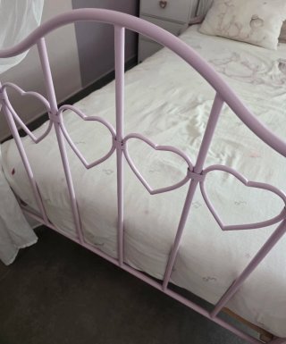 Cama con dosel rosa y cortinas blancas