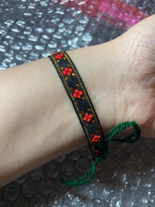 Pulsera tejida con cuentas rojas y negras