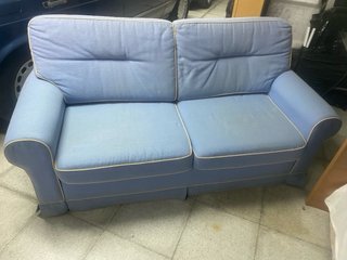 Sofá Cama en tela azul con ribetes blancos.