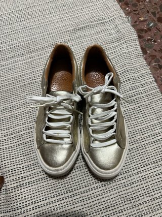 Zapatillas Zara doradas.