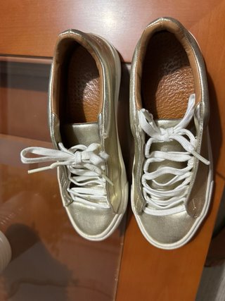 Zapatillas Zara doradas.