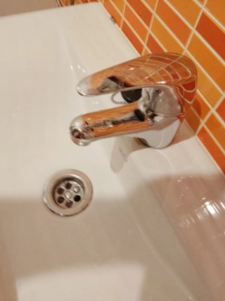 Mueble de baño rojo y blanco con lavabo y grifo