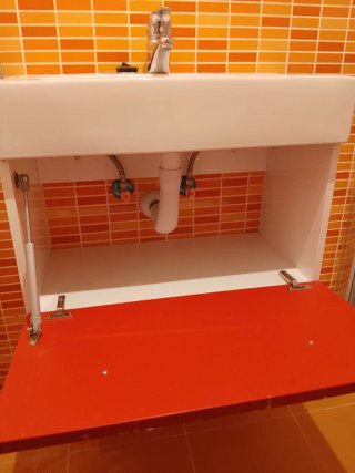 Mueble de baño rojo y blanco con lavabo y grifo