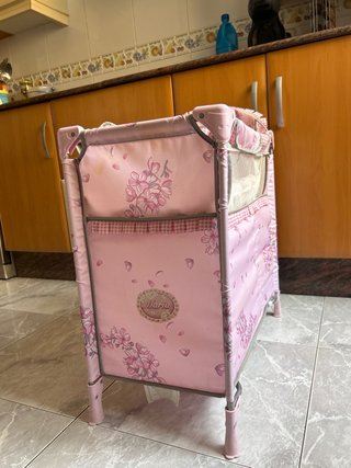 Cuna de juguete rosa con estampado floral