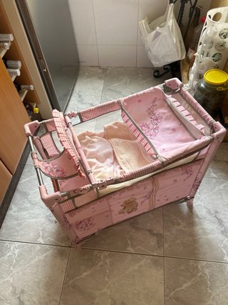 Cuna de juguete rosa con estampado floral