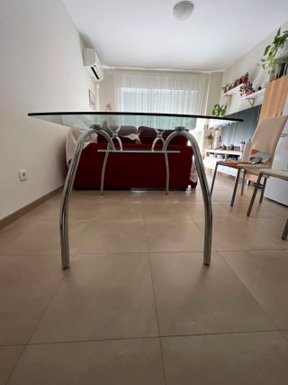 Mesa de cristal con balda en la parte inferior.