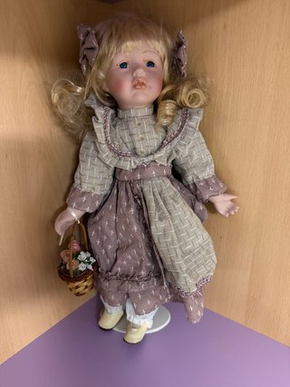 Muñeca de porcelana con cesta de flores