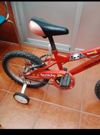 Bicicleta infantil roja con ruedines