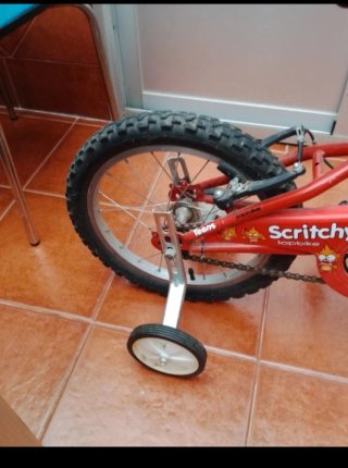 Bicicleta infantil roja con ruedines