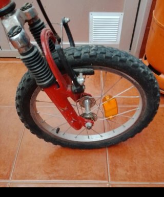 Bicicleta infantil roja con ruedines