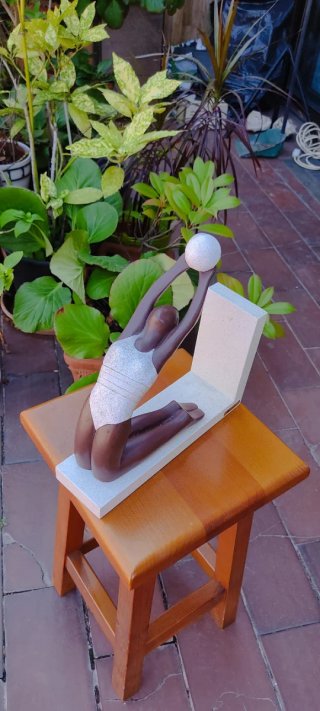 Figura sujeta libros con esfera y base