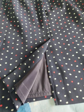 Vestido azul marino con topos blancos y rojos.