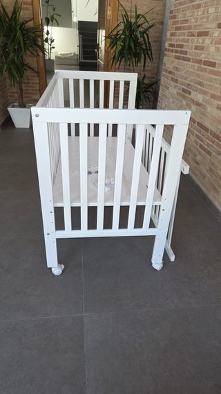 Cuna de bebé blanca con ruedas