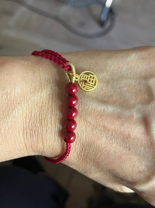 Pulsera roja con charm dorado