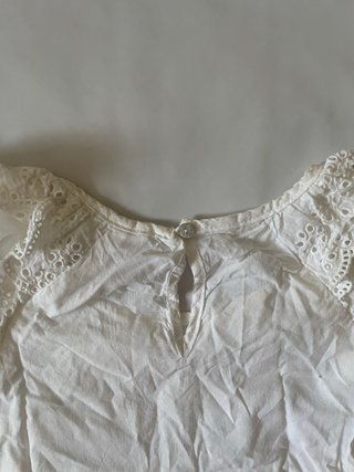 Blusa blanca manga corta volantes perforados.