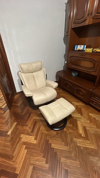 Sillón de cuero beige con reposapiés
