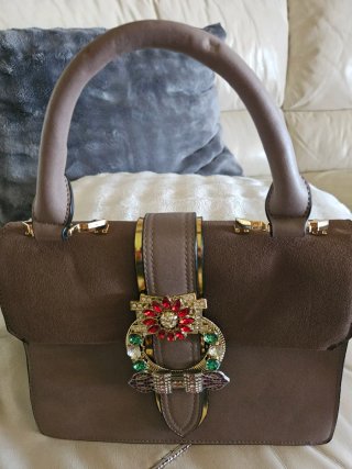 Bolso de mano gris con adornos