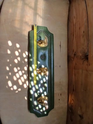 Perchero de cuero verde con adornos dorados